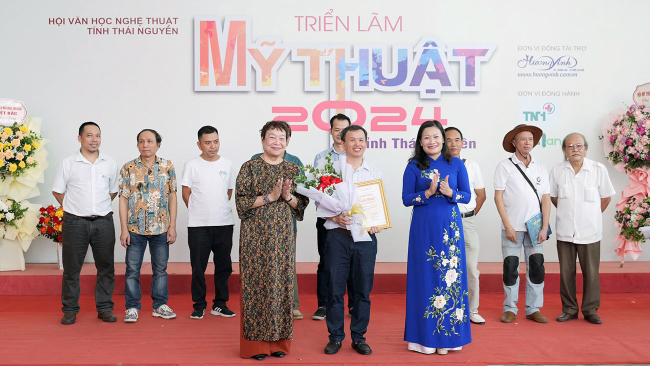 Họa sĩ Mai Thị Ngọc Oanh, Phó Chủ tịch Thường trực Hội Mỹ thuật Việt Nam (bên trái) và đồng chí Mai Thị Thúy Nga, Phó Chủ tịch Thường trực HĐND tỉnh trao giải Nhất Cuộc thi cho họa sĩ Dương Văn Chung với tác phẩm “Nắng trên nương”