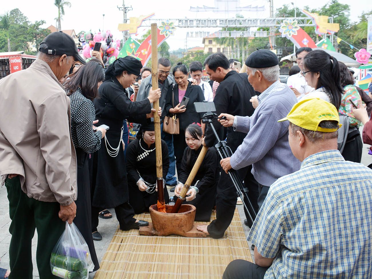 Nghệ nhân và du khách trải nghiệm giã bánh giầy