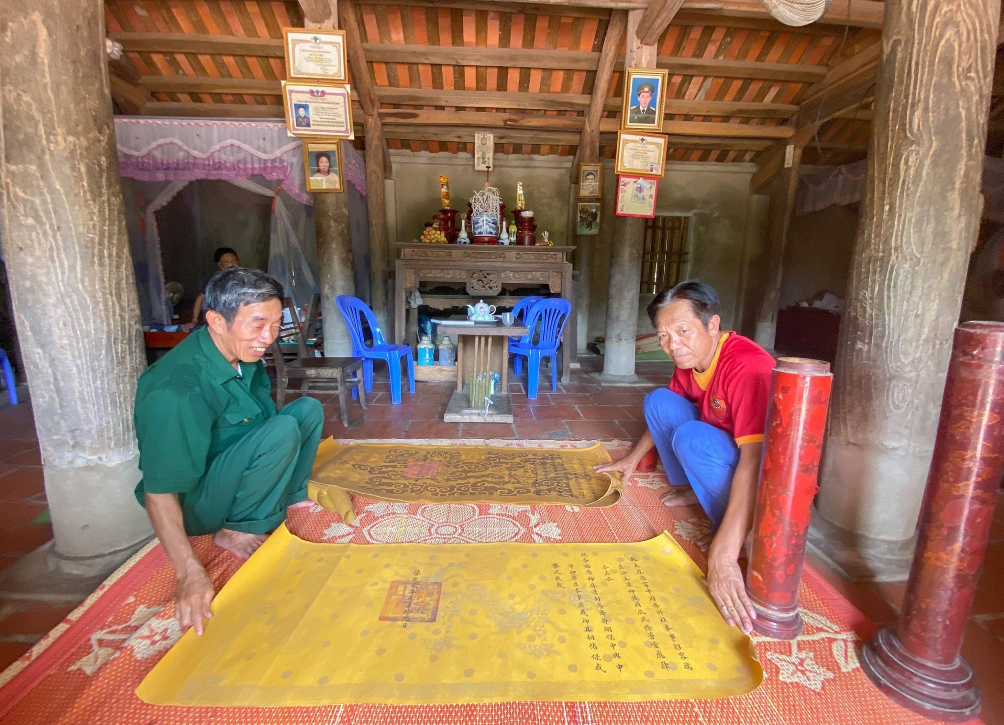 Ông Nguyễn Viết Bằng (bên trái) và ông Tạ Văn Thảnh giới thiệu các sắc phong của đình làng