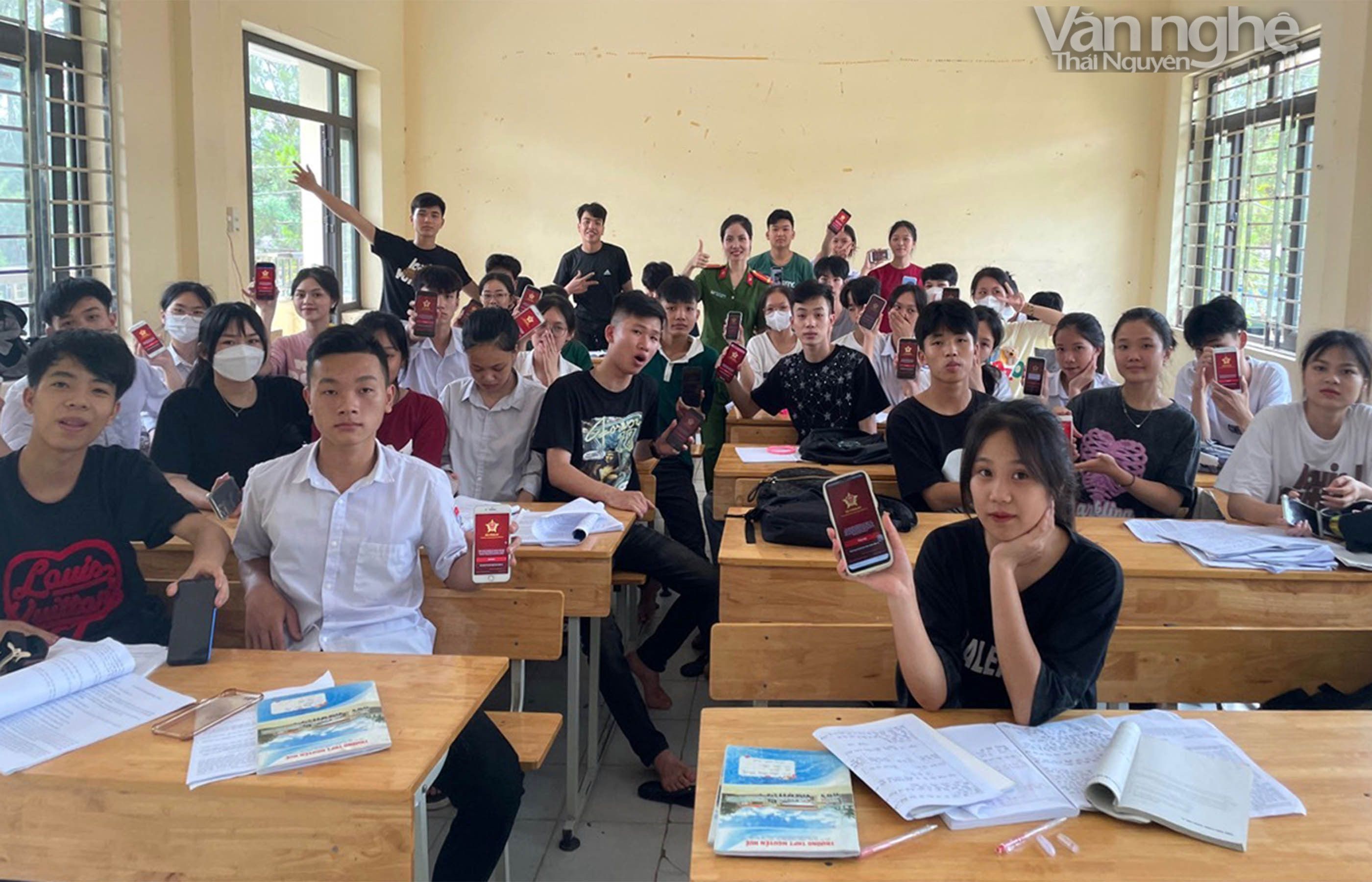 Trung uý Lê Thị Thuỳ Dương chụp ảnh lưu niệm với các em học sinh sau khi hoàn thành hướng dẫn cài đặt định danh điện tử VneID