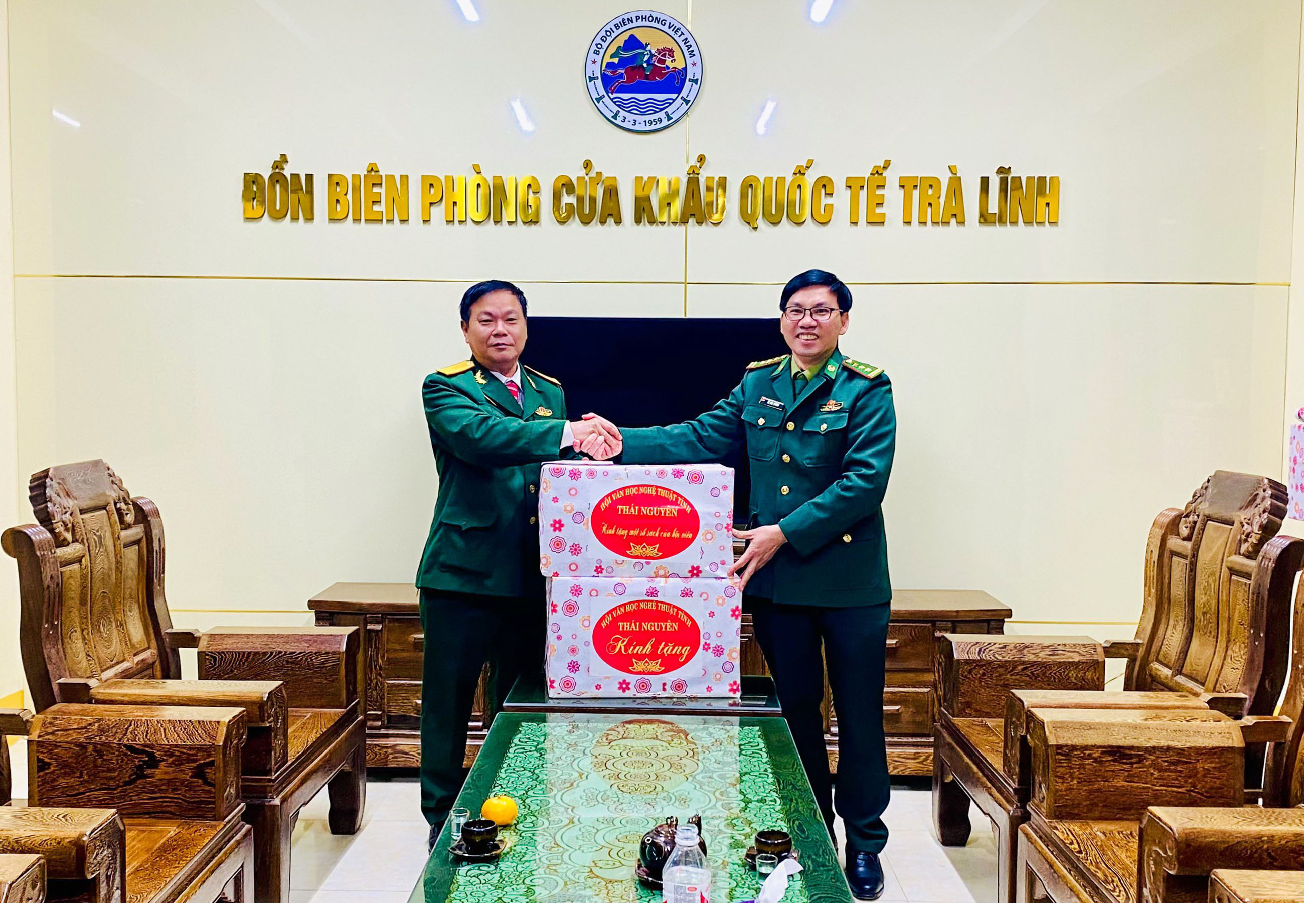 Tác giả (trái) thay mặt Hội Văn học nghệ thuật tỉnh Thái Nguyên trao tặng quà cho cán bộ, chiến sĩ Đồn Biên phòng Cửa khẩu quốc tế Trà Lĩnh