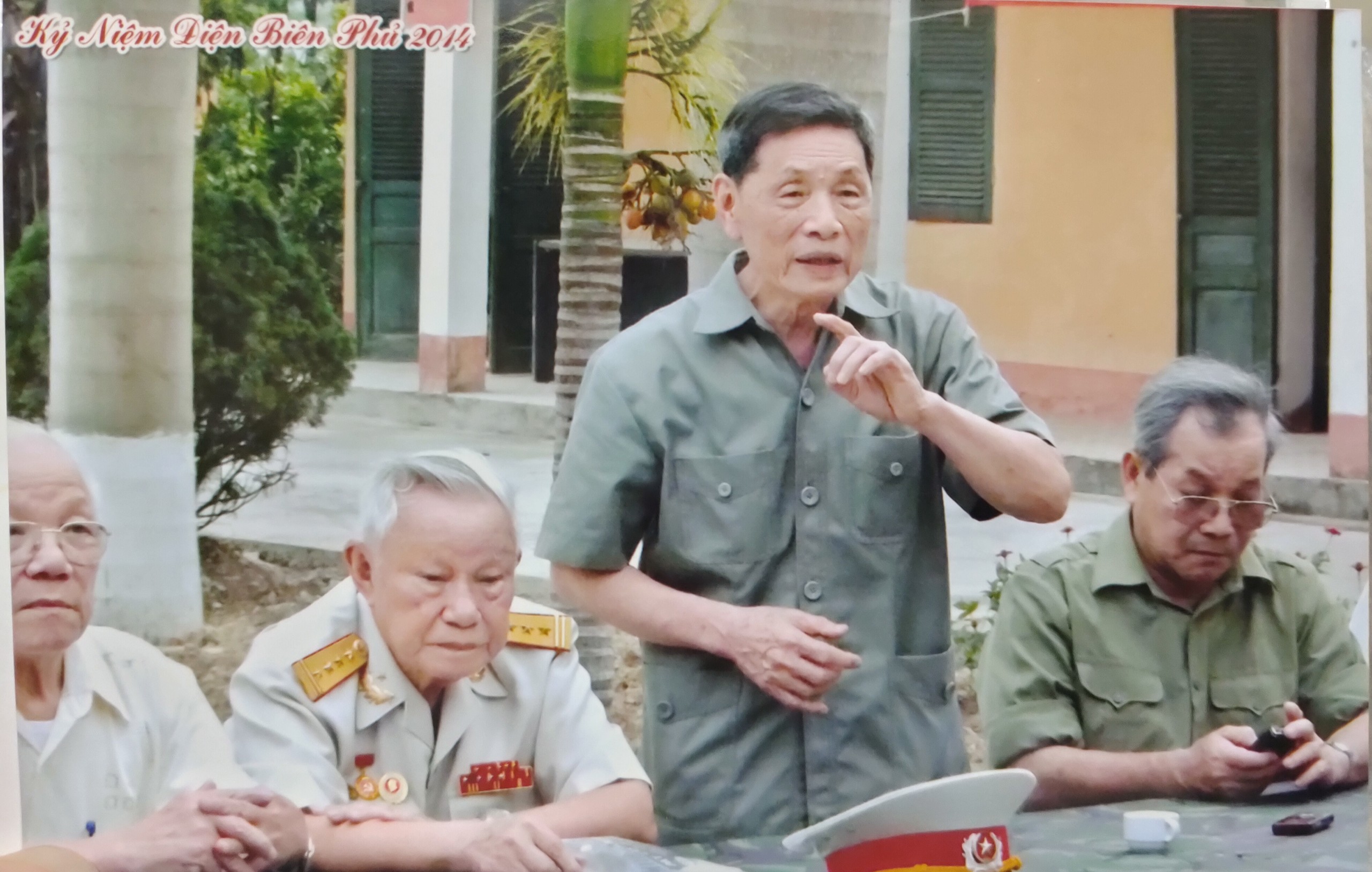 Đại tá Vũ Đình Hoè (người đứng) ôn lại kỷ niệm chiến đấu tại đồi A1 cùng đồng đội (2014). Ảnh tư liệu gia đình