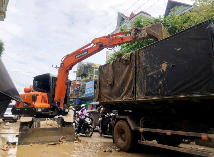 Máy múc và xe tải khẩn trương dọn dẹp tuyến đường