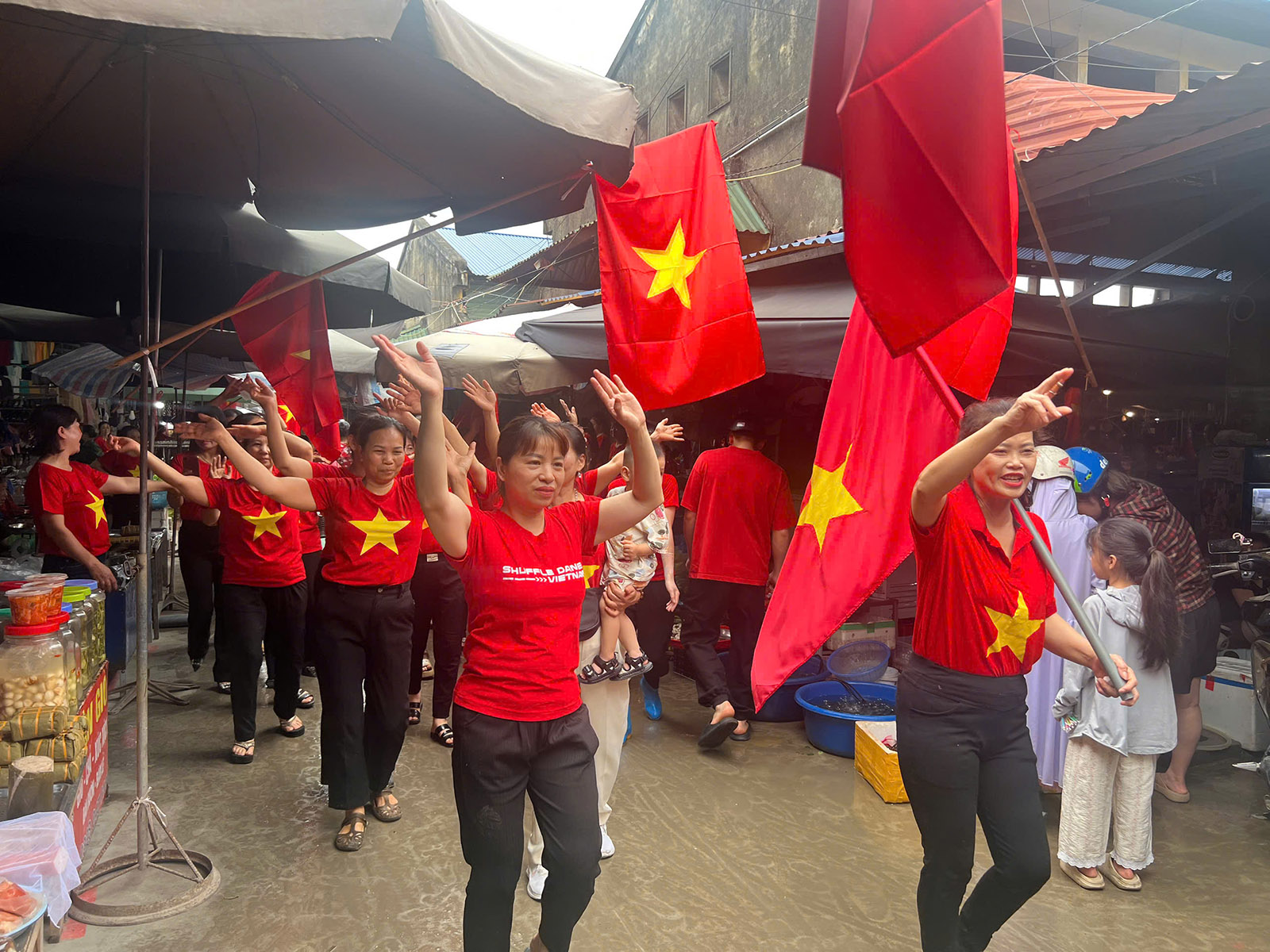 Bà con tiểu thương diễu hành qua các hàng quán trong Chợ Chùa Hang