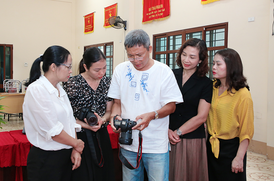 Nghệ sĩ Nhiếp ảnh Lưu Quang Phổ hướng dẫn học viên điều chỉnh các thông số trên máy ảnh trong giờ giải lao